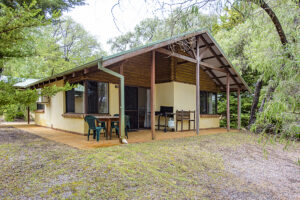 Wiry Wattle – Wyadup Brook Cottagessurrounded by native bushland, featuring a shaded front veranda and outdoor seating.